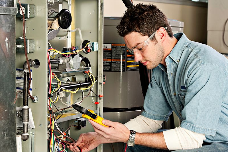 Image of a technician working with an AC unit. Why Do I Need AC Maintenance Now?